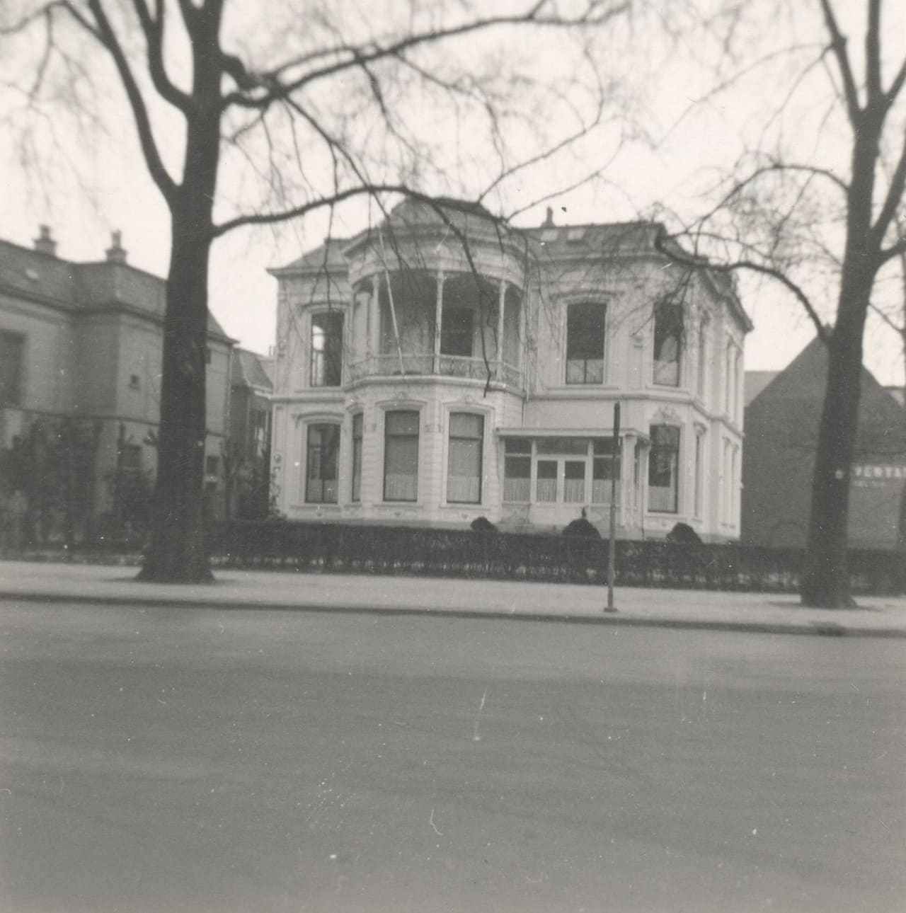 Zwart-witfoto van de oostzijde van de Sophialaan met de villa achter kale bomen.