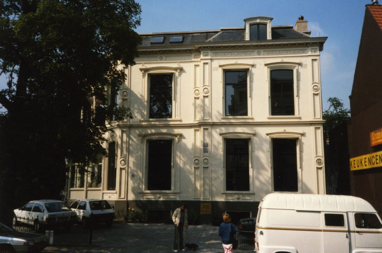 Kleurenfoto van de zijgevel aan de Van Swietenstraat, juli 1988, met geparkeerde auto’s.
