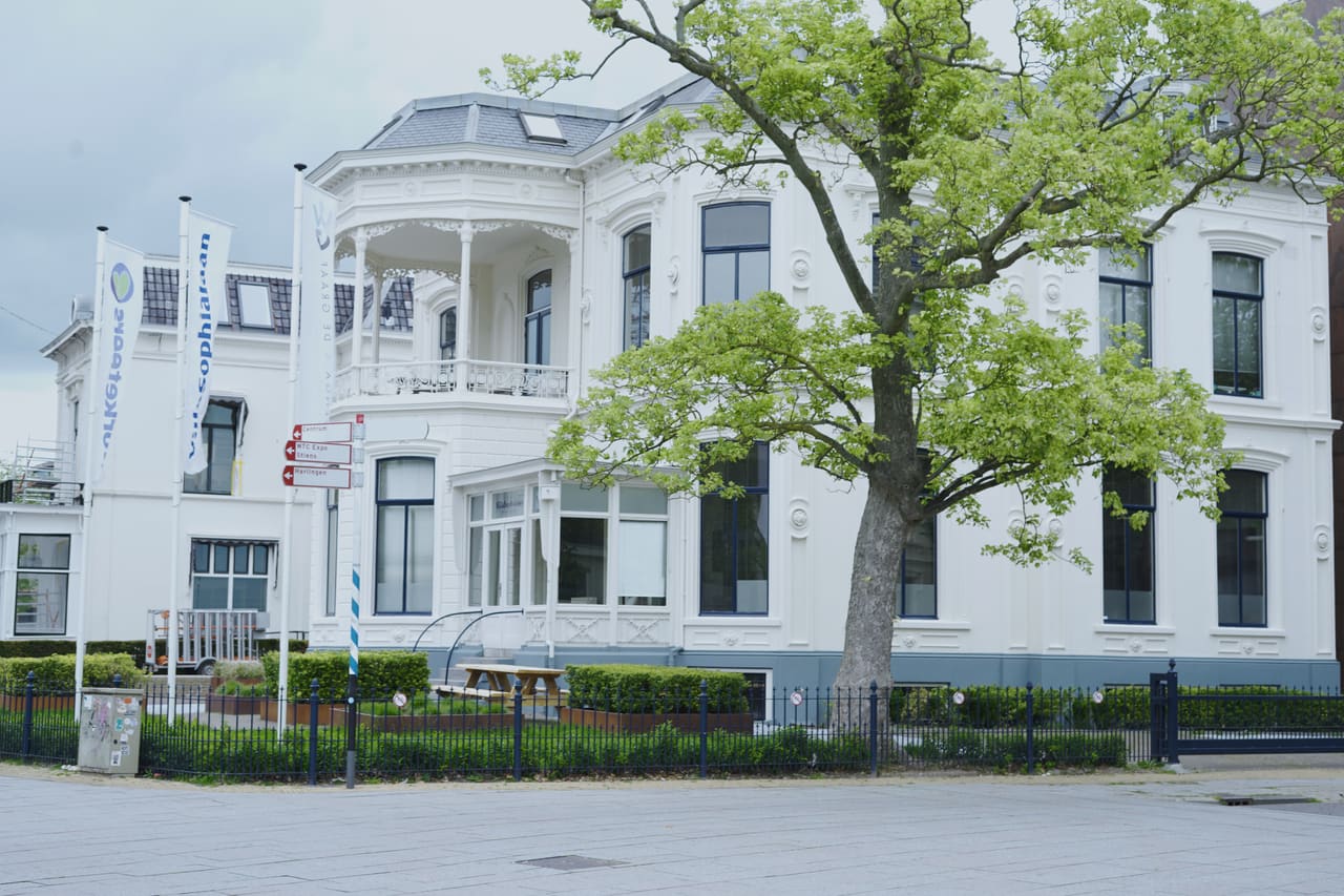 Villa Sophialaan gezien vanaf de laan, met bomen ervoor en de erker en het balkon aan de rechterzijde.