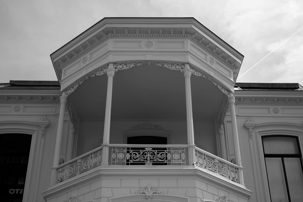 Het overdekte balkon van Villa Sophialaan van onderaf gezien, met balustrade en gietijzeren kolommen.